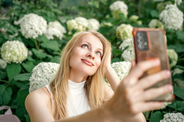A woman is taking a selfie with her cell phone