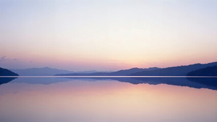 Fototapeta premium Serene horizontal panorama of a calm lake perfectly mirroring the purple, pink, and orange pastel tones of the sunrise or sunset sky.