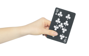 playing card clubs 9 in hand, outstretched hand with black playing card isolated from background