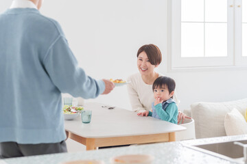 家族で食べる料理を配膳する父親