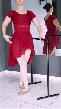 Ballerina performing battement d&eacute;gag&eacute; &agrave; la devant beside the barre. Vertical video designed for dance tutorial, ballet tutorial, dance training and beginner ballet students.
