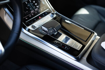 Modern and expensive car interior and gearbox shift handle. Close up of the automatic gearbox lever, black interior car. Automatic transmission gearshift stick. Automatic transmission shift lever.