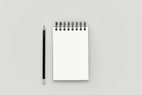 Blank spiral notebook notepad and pencil on background. Flat lay design mockup with empty space. Planning banner color of 2026 year