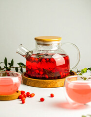 A glass of red tea is on a wooden tray