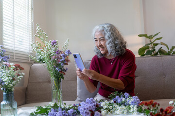 Senior Woman Taking Photo of Her Floral Arrangement