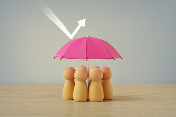 Group of wooden pawns under pink umbrella - Concept of insurance, woman and social protection