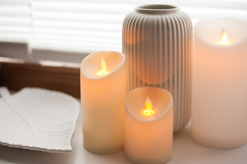 Led battery candles, tray and vase over white background with soft window light.