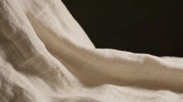 Extremely close-up detail shot of ivory linen fabric waving gently and slowly against a pure studio void with soft lighting creating subtle undefined shadows meditation, ivory, website
