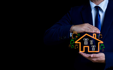 Businessman holding glowing house icon with financial cost, loan and investment symbols, representing property protection and real estate planning.