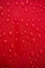 Bright red surface adorned with water droplets, showcasing natures beauty in simple yet captivating detail