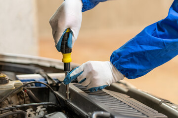 car mechanic hands and screwdriver tools working on automobile performance. Young man motor technician, repair service and maintenance vehicle machine oil inspection