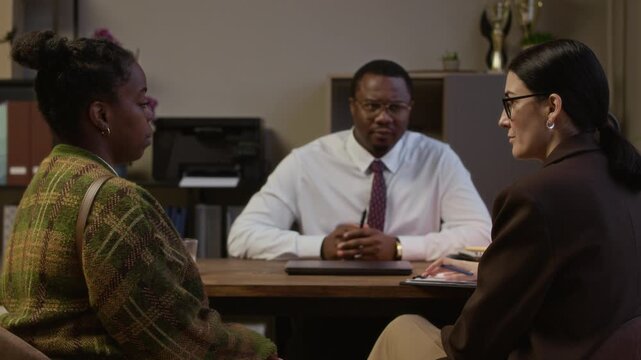 Stab shot of African American woman communicating with female Caucasian counselor and male principal during appointment in office