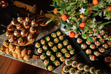 Top view of buffet table with canapes, flowers and oranges - luxurious catering setup