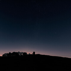 Old John tower silhouette under starry night sky above Leicestershire hillside