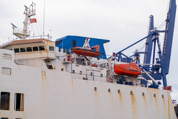 Bosphorus port activity featuring a cargo ship and loading equipment at twilight