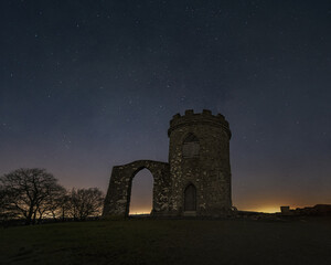 Starry night sky frames Old John tower as the hill stands in silhouette