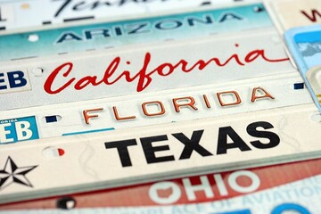 Old US car license plates with various state names. Concept of driving in United States. Reaching a car registration