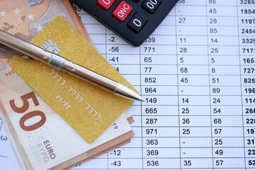 Credit card and pen with euro currency money bills banknotes on calculations document background. Business, financial operations and accounting in European Union