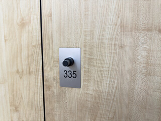 Locker number 315 with modern locking mechanism. Public locker with number in gym locker room with light wood interior. Storage concept for gym locker room during exercise