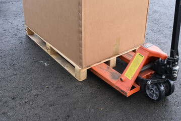 Cardboard box on pallet being moved with manual pallet jack