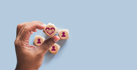 Hands holding wood cube with empathy leadership icon. symbolizing supportive management, trust building, human centered teamwork, workplace connection for corporate use. Empathy in leadership concept