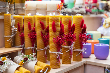 Natural tall beeswax candles with a honeycomb texture and dried flower decor