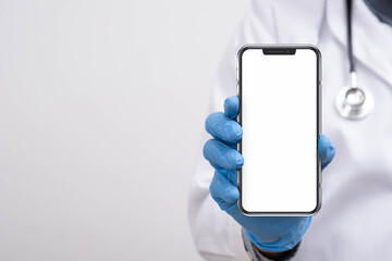 A healthcare professional wearing blue gloves holding a smartphone with a blank white screen, ideal for medical app promotion, telehealth services, digital healthcare technology, and modern clinical.