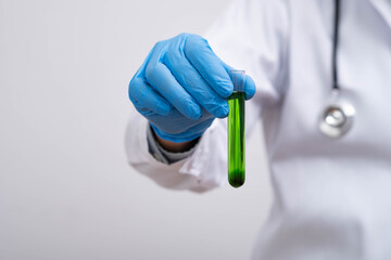 A scientist holding a test tube with green liquid in a laboratory setting, showcasing medical research, chemical analysis, and biotechnology experiments for scientific and healthcare concepts.
