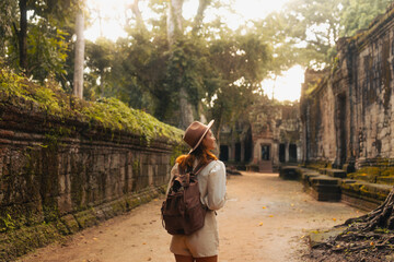 Female Traveler Exploring Ancient Angkor Temple Passage At Sunrise Light