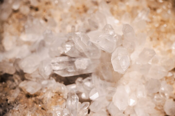 Natural clear quartz crystal cluster with transparent elongated hexagonal formations on a rough stone matrix