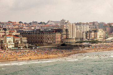 Biarritz, France. Telephoto view of the Hotel du Palais and surrounding buildings, with Miramar Beach crowded below on a summer day, taken from the Biarritz Lighthouse
