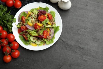 Tasty salad with lentils and vegetables on grey textured table, flat lay. Space for text