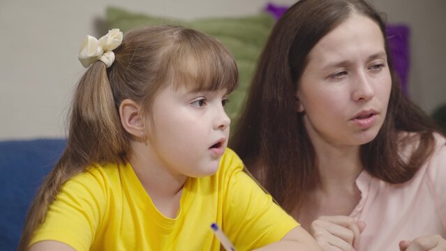 girl school student teaches lessons with mother. mother daughter are working test digital laptop.active teamwork. school life little student. home school tutor. child kid training indoors together.