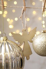 Fototapeta premium Beautiful Christmas decor hanging on string against blurred lights, closeup