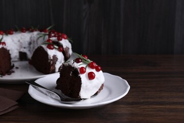 Tasty Christmas cake with cranberries and rosemary served on wooden table, closeup. Space for text