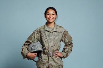 Asian female young adult soldier smiling in uniform holding helmet