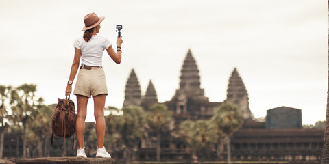 Naklejka premium Angkor Wat Vlogger: Female Traveler Filming Iconic Temple, Cambodia