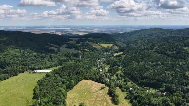 Aerial drone summer panoramic view of Ladek Zdroj town nestled in scenic Klodzko Valley Poland, surrounded by lush greenery and rolling hills of the Golden Mountains