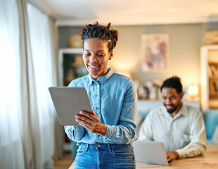 Portrait of a young black man and woman, a young couple, or businessman and businesswoman, using tablet and laptop in home office, business and teamwork, cooperation and brainstorming concept