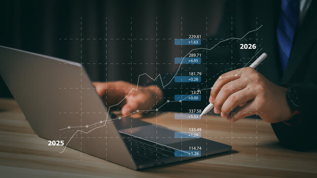 Businessman analyzing stock market trend 2026 with stylus on laptop. Concept of financial investment growth, economic forecast, and global business profit strategy from year 2025.