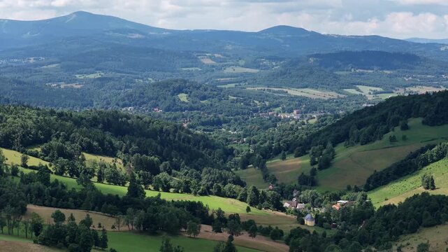Aerial drone summer panoramic view of Ladek Zdroj town nestled in scenic Klodzko Valley Poland, surrounded by lush greenery and rolling hills of the Golden Mountains