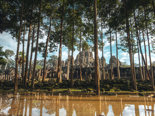 Obraz premium Bayon Temple Framed By Jungle Trees And Reflection Pool, Cambodia