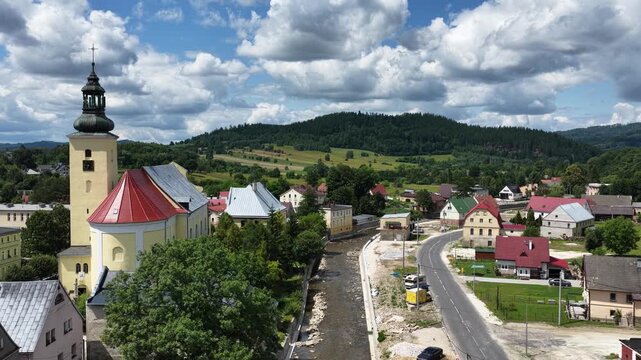 Aerial drone summer panoramic view of Ladek Zdroj town nestled in scenic Klodzko Valley Poland, surrounded by lush greenery and rolling hills of the Golden Mountains