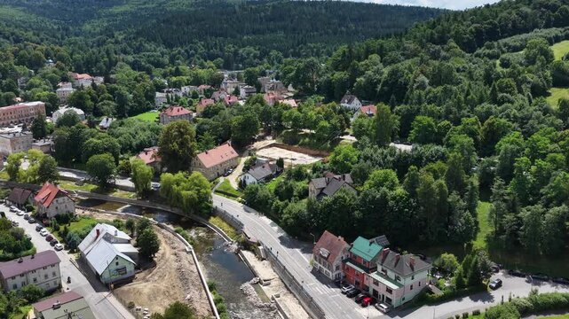 Aerial drone summer panoramic view of Ladek Zdroj town nestled in scenic Klodzko Valley Poland, surrounded by lush greenery and rolling hills of the Golden Mountains