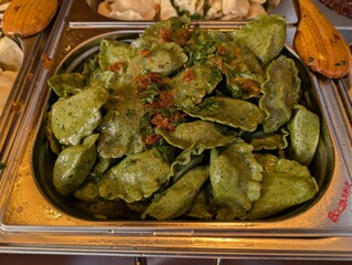 Spinach dumplings served with herbs at a festive food stall. Traditional market cuisine.