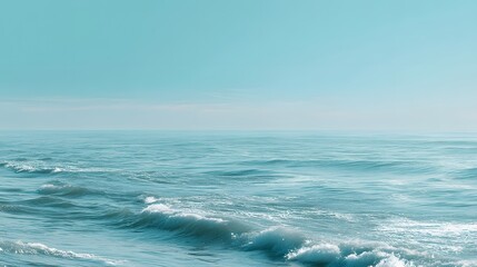 Fototapeta premium Serene ocean waves gently rolling under clear blue sky with calm water and distant horizon in a peaceful seascape scene
