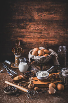 Assorted baking ingredients on rustic bronw table