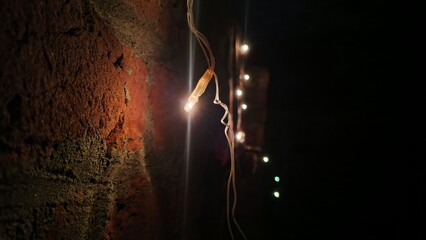 Macro View of Fairy String Lights Against a Dark Rustic Red Brick Wall at Night