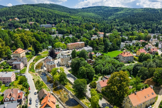 Aerial drone summer panoramic view of Ladek Zdroj town nestled in scenic Klodzko Valley Poland, surrounded by lush greenery and rolling hills of the Golden Mountains