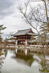 Naklejka premium Nara, Japan - Mach 28, 2025: Scenic view of Todaiji Kagami-ike Pond with Todaiji Chumon (Central Gate) in Nara, Honshu island in Japan
